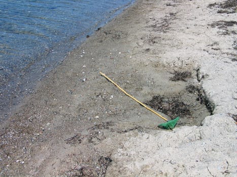 Children's toy fishing net on the beach