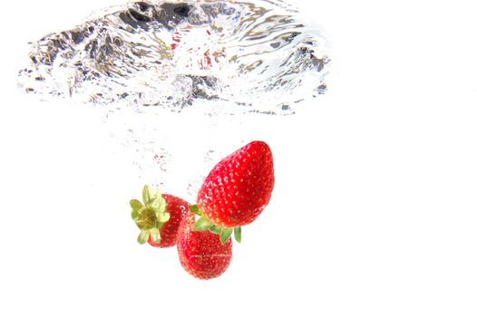 strawberry splash in warter showing healthy lifestyle