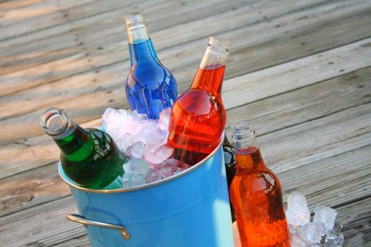An assortment of colorful soda in an ice bucket.