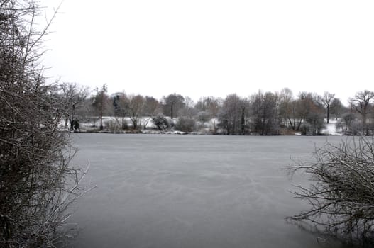 A view of a lake in winter with snow