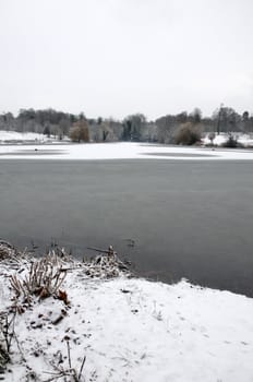 A view of a lake in winter with snow