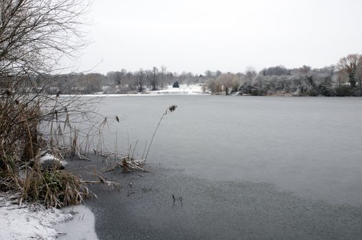 A view of a lake in winter with snow