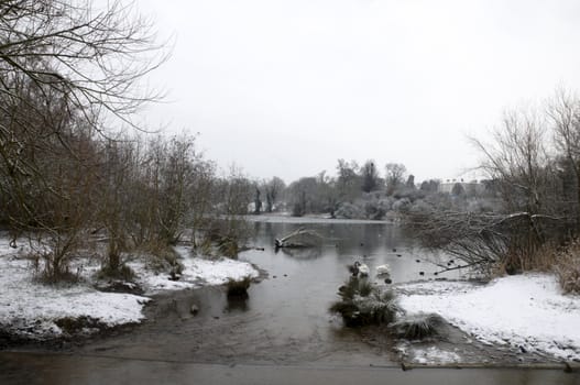 A view of a lake in winter with snow