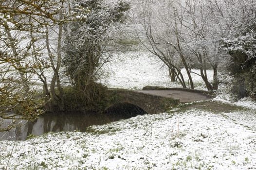 An arch bridge over a stream in winter