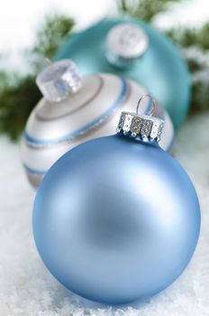 Closeup of three Christmas decorations sitting in snow