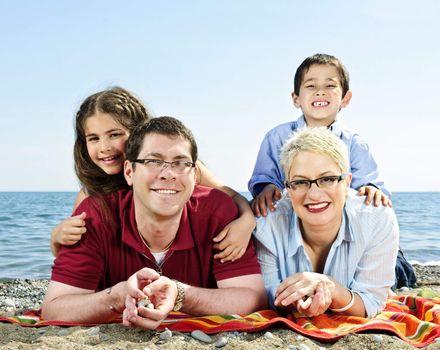 Happy family laying on towel at sandy beach