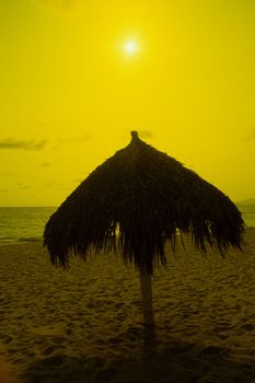 sihlouette of a grass umbrella and chair Cancun Mexico