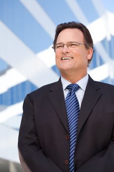 Handsome Businessman Smiling in Suit and Tie Outside of Corporate Building.