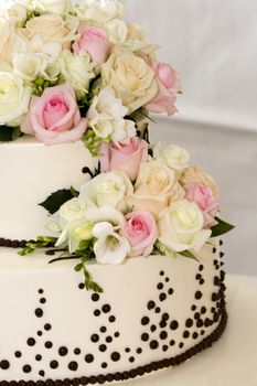 details of beautiful tiered wedding cake with flowers