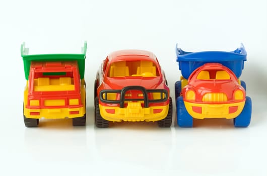 Three toy cars in a row, isolated on a white background.