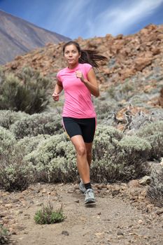 Running. Woman trail running outdoors on the volcano. Teide, Tenerife. Mixed chinese / caucasian woman model.