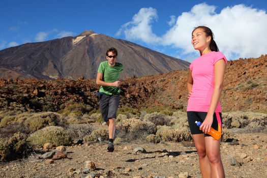 Running. Couple trail running in spectacular volcano landscape on Teide, Tenerife. 