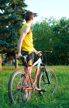 The sportsman stands near to a bicycle and looks afar