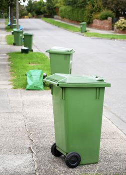 Row of green recycling bins in urban street