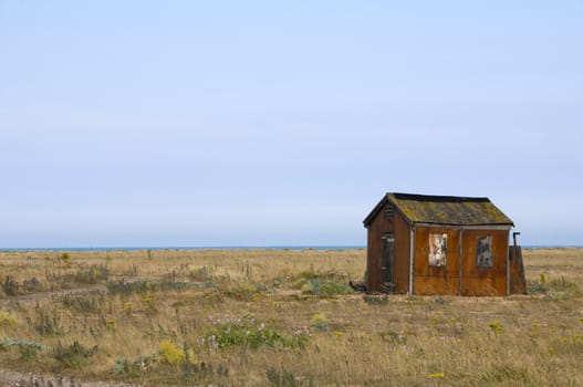 An old abandoned fishing hut on a shingle beach