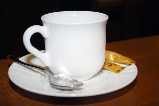 cup, saucer and teaspoon on a table