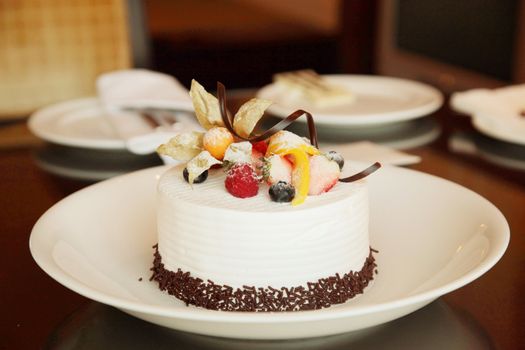 White Cream Icing Cake with Fruits and Chocolate