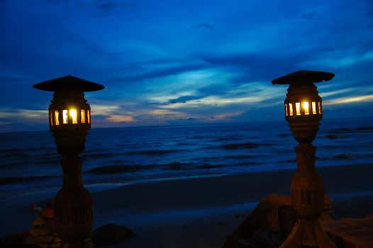 Two lampposts' silhouettes on dark blue sky