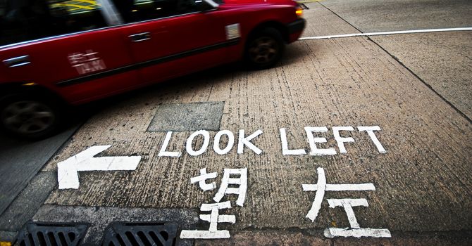 A sign at a street crossing in Hong Kong reminding tourists to look left before crossing