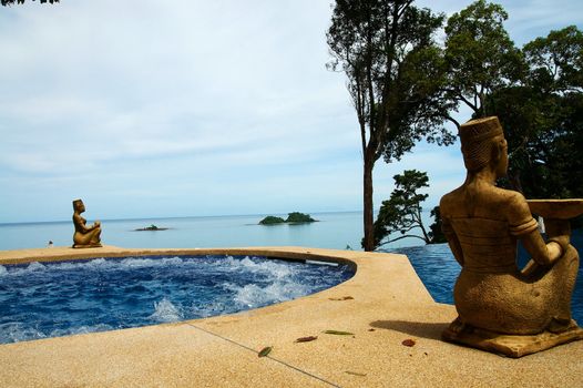 jacuzzi, statuettes and trees near spa pool