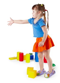 The little girl in a dress with toys on a white background