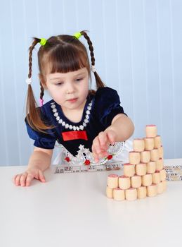Preschool-age girl playing with wooden Lotto