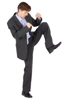 A young man kicks, isolated on a white background