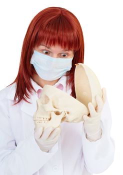 Young woman in amazement looking at the skull, isolated on a white background