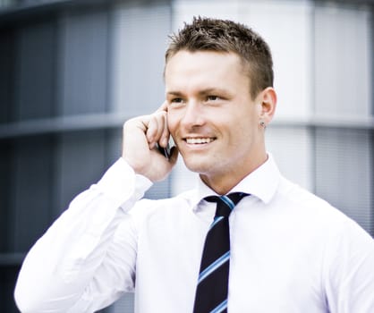 Corporate Young Man On Cellular Phone And Smiling