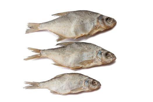 Three dry salted fishes over white background