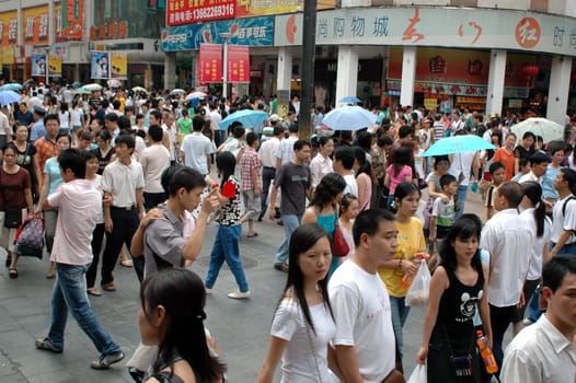 Crowd of people in Shenzhen city, Guangdong province, China. Spending their time in city center, shopping malls.