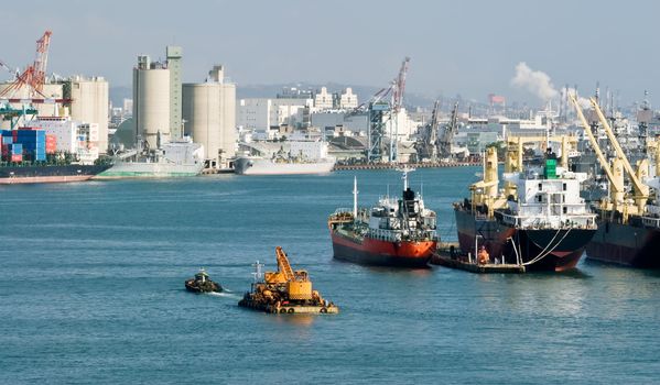 Cityscape of harbor with freighter on water of harbor and industry buildings in Kaohsiung, Taiwan.