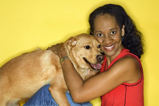 African American prime adult female petting dog.