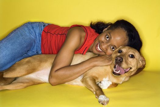 African American prime adult female hugging dog.