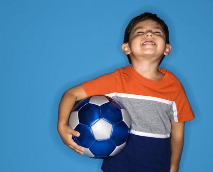 Male Hispanic boy holding soccer ball.