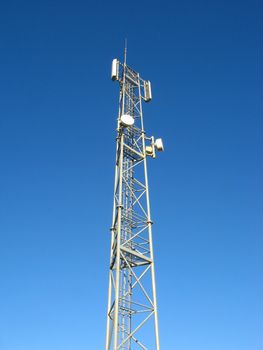 image of a pylon with antennas in a blue sky