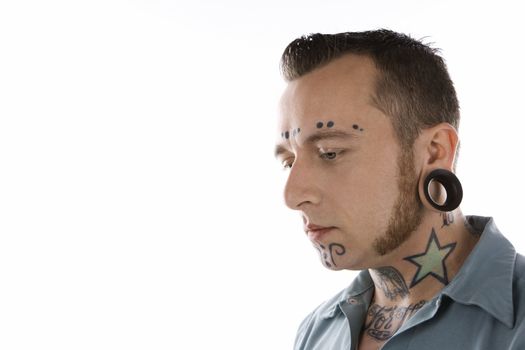 Caucasian mid-adult man with tattoos and piercings.