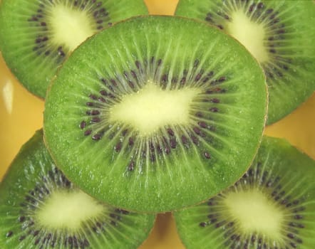 a close-up image of kiwis on a yellow plate