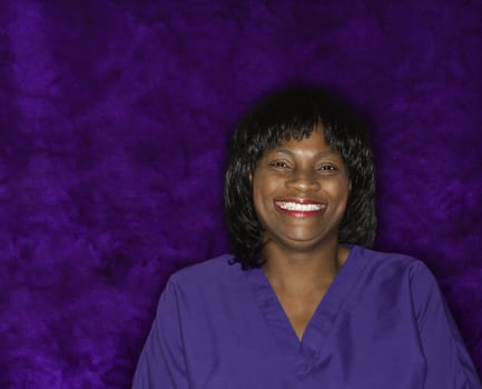 African-American mid-adult woman in medical uniform smiling.