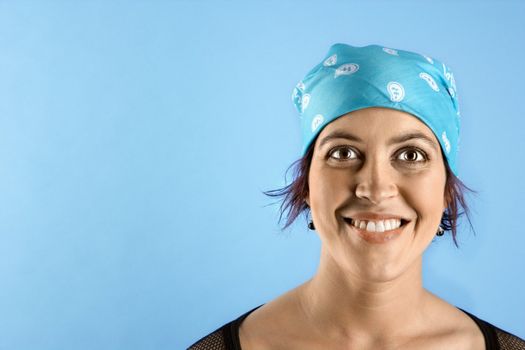 Hispanic mid-adult woman wearing bandana on head and smiling.