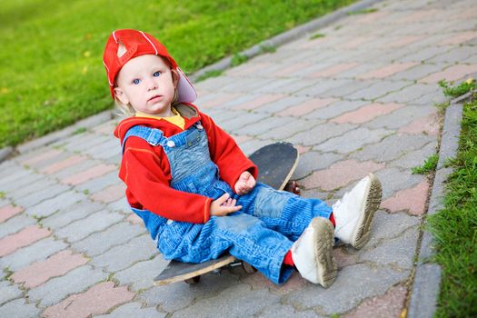 child of 2 years old sitting on the skateboard