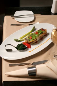 restaurant table with fish asparagus and spinach plate