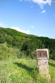 milestone marked with eight and positioneda on a hill