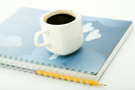 coffe cup, yellow pencil and spiral notebook