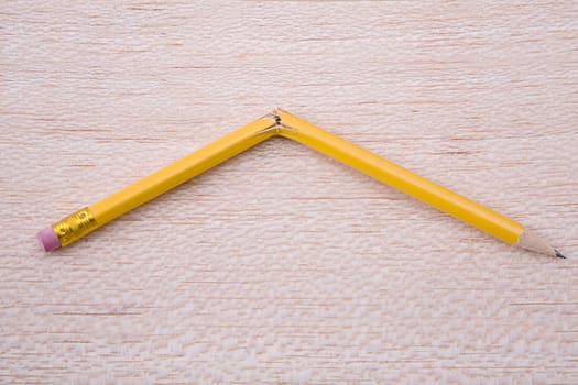 broken pencil on wooden board