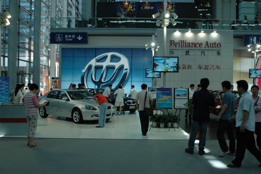 China, Shenzhen Moto - car show in exhibition center. Visitors watching European, American and Chinese cars. Crowd of people interested in newest moto technology.