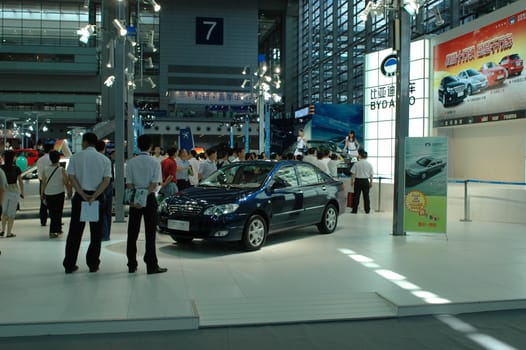 China, Shenzhen Moto - car show in exhibition center. Visitors watching European, American and Chinese cars. Crowd of people interested in newest moto technology.