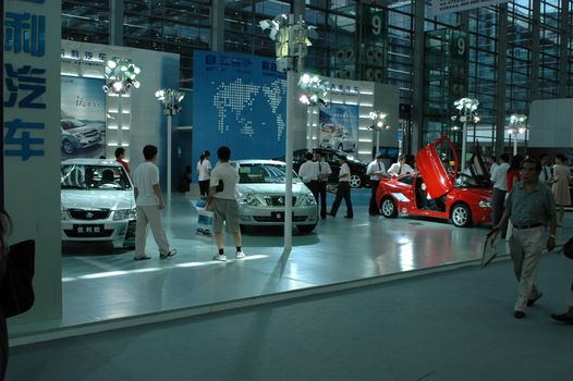 China, Shenzhen Moto - car show in exhibition center. Visitors watching European, American and Chinese cars. Crowd of people interested in newest moto technology.