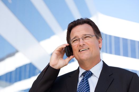 Confident, Handsome Businessman Smiles as He Talks on His Cell Phone Outdoors.