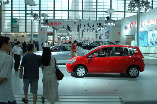 China, Shenzhen Moto - car show in exhibition center. Visitors watching European, American and Chinese cars. Crowd of people interested in newest moto technology.